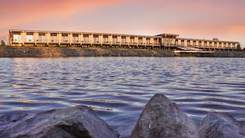 Un hotel amb façana al mar, amb una filera de habitacions que donen a l'aigua.