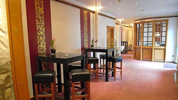 Une chambre d’hôtel dotée d’un coin repas avec une table et des chaises, d’une grande fenêtre offrant une vue et d’un sol recouvert de moquette.