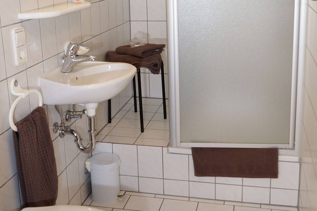 Un baño con inodoro, lavamanos y ducha.