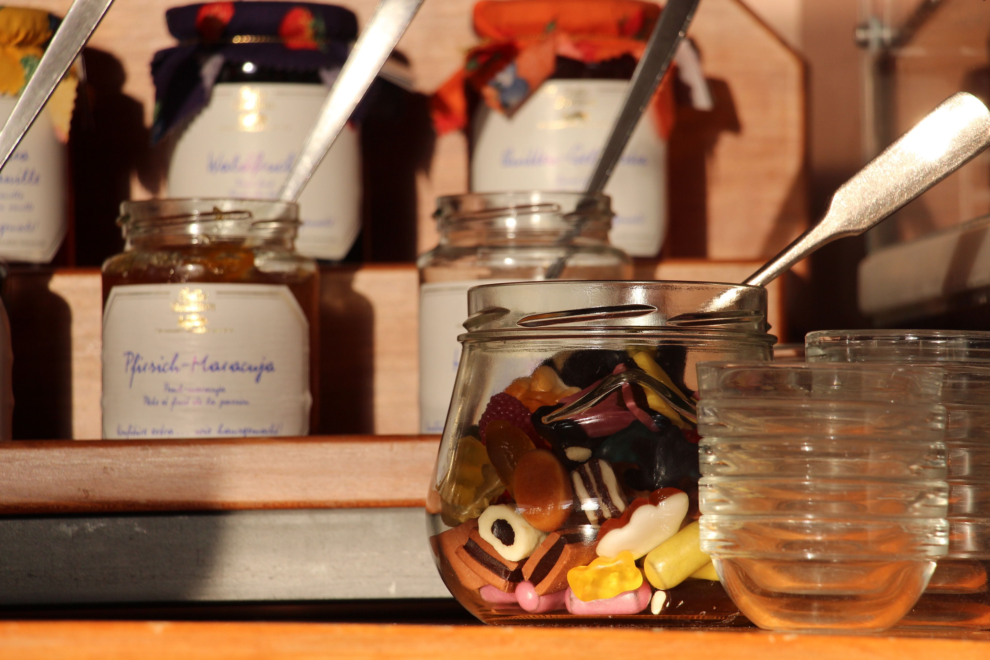Una exhibición de botes y recipientes diversos con etiquetas, presumiblemente conteniendo alimentos o condimentos.