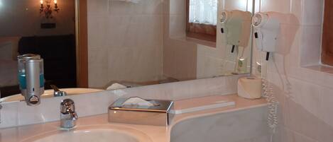 A bathroom with a sink, mirror, and toilet.