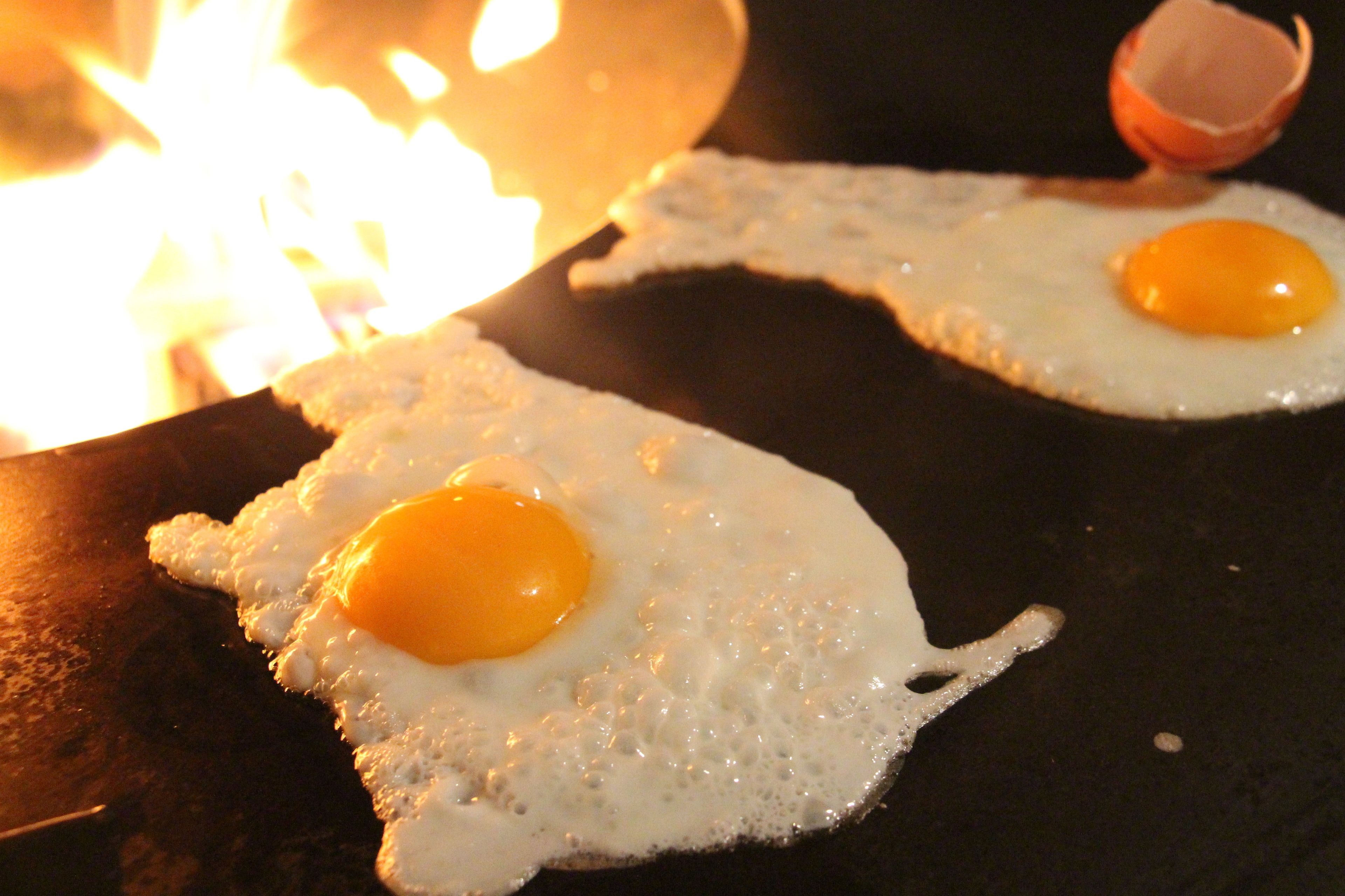 Deux œufs au plat sur une poêle noire.