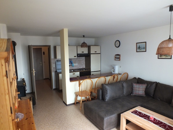 A compact living space with a kitchenette, a dining area, and a sofa.