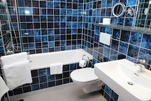 A bathroom with a bathtub, toilet, and sink, all with white fixtures.