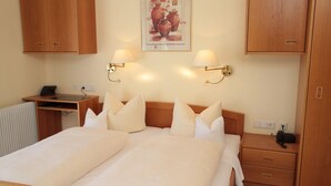 A hotel room with a bed, bedside tables, a desk, and a wardrobe. - Hotel Anika (Neuenburg am Rhein)