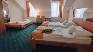A hotel room with two beds, a desk, and a chair. - Hotel Grand (Hradec Kralove)