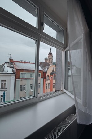 A window with a view of buildings and a clock tower.