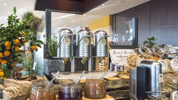 A beverage station with multiple dispensers and jars of drinks.