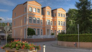 A multi-story building with a consistent architectural style, featuring a series of windows and doors.