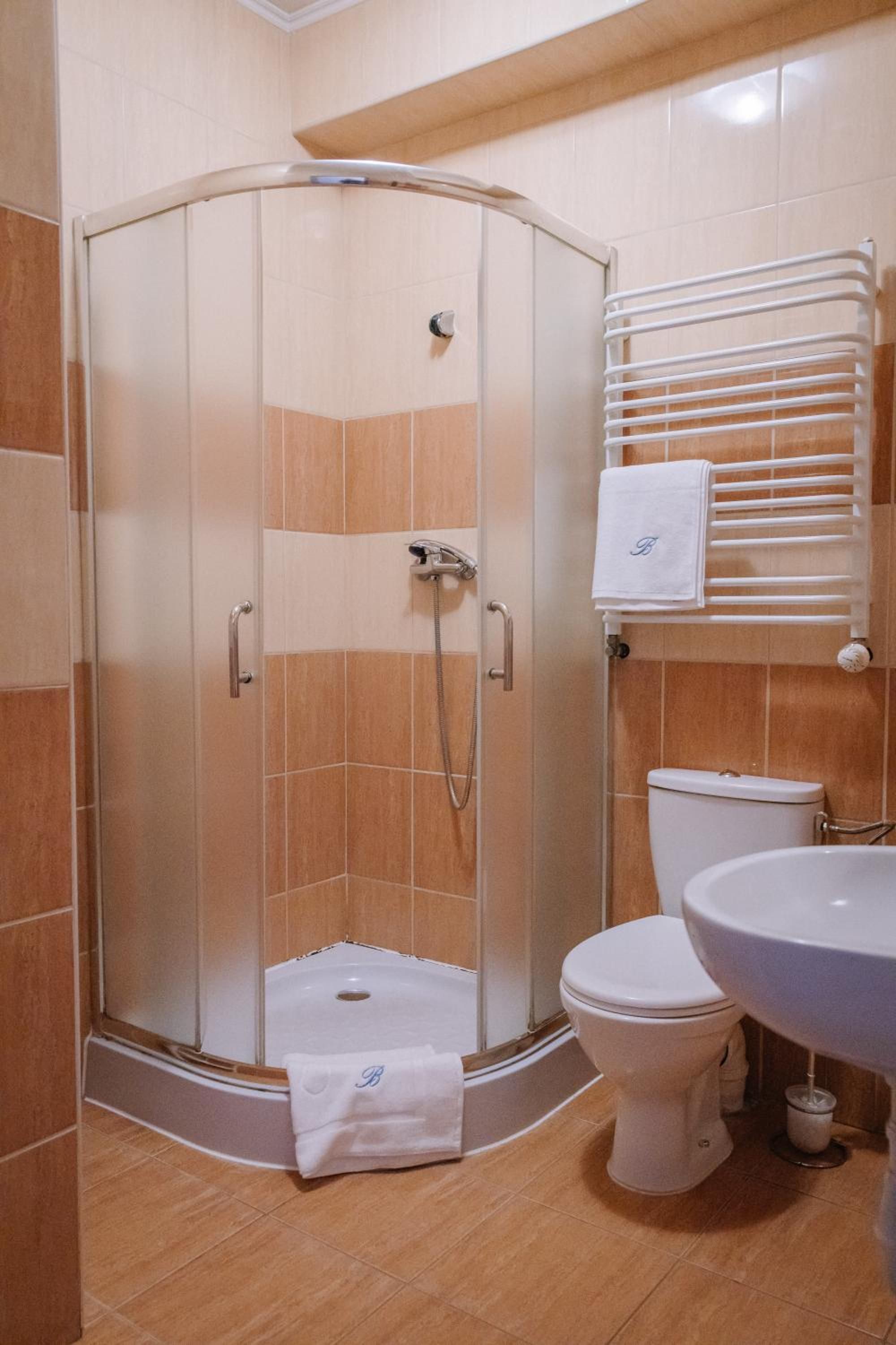 Un bagno con doccia vetro, toilette e lavandino.