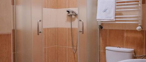 Un bagno con doccia vetro, toilette e lavandino.