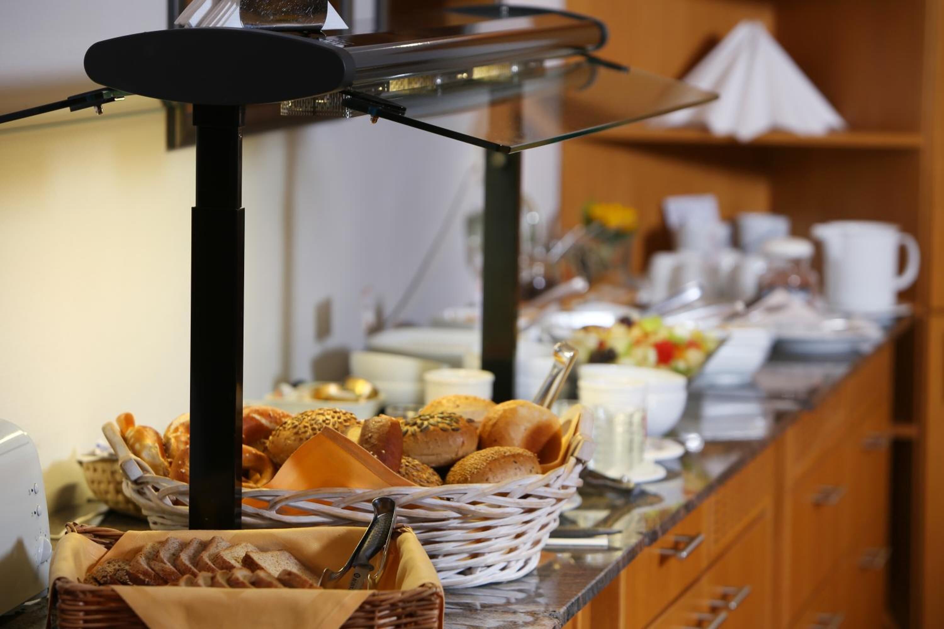 A buffet setup with various food items and utensils.