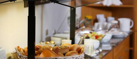 A buffet setup with various food items and utensils.