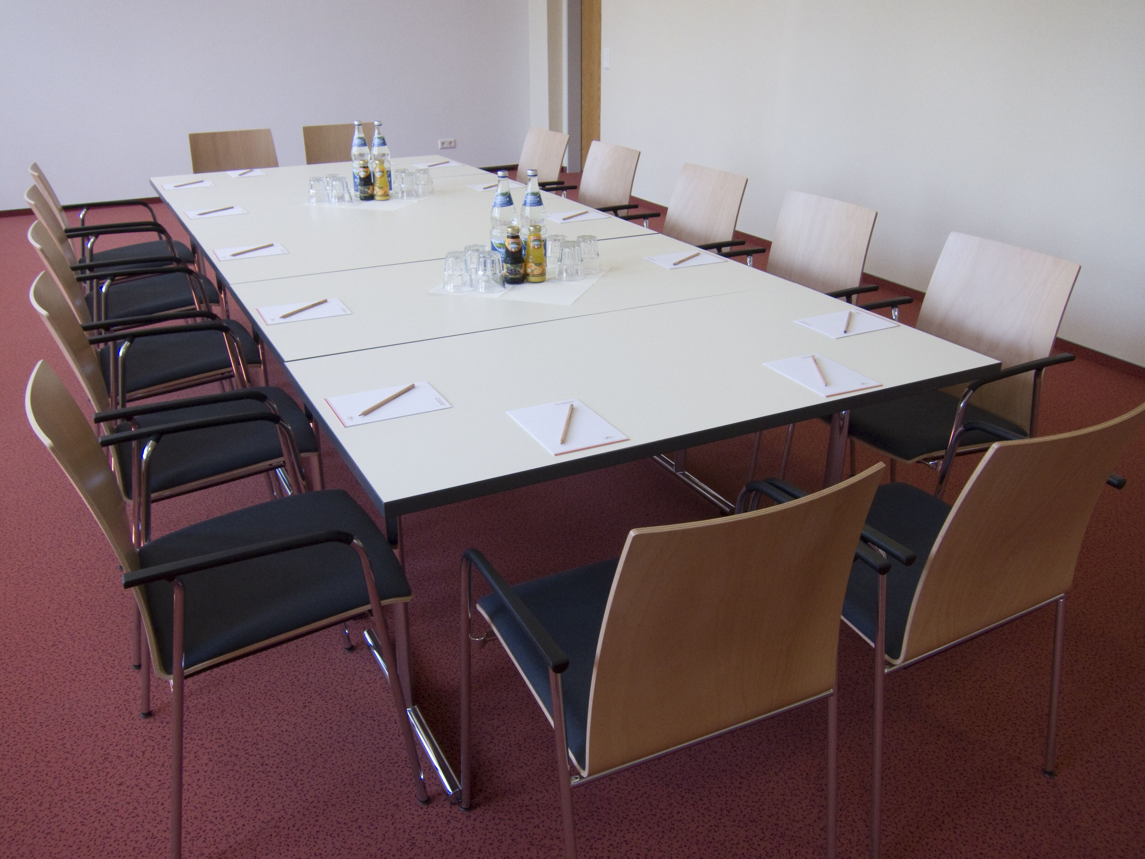A conference room with a long table, chairs, and water bottles.
