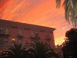 Un edificio con balcón y fachada roja.