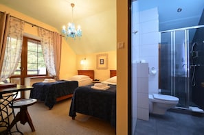 A hotel room with two beds, a chandelier, a shower area, and a view of the outdoors. - Dworek Nad Reg O (Trzebiatow)