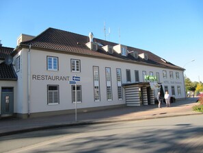 Un edificio de dos pisos con un letrero que indica un restaurante en la planta baja.
