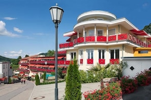 A multi-story building with balconies, a street lamp, and a clear sky. - Wellness Privathotel Post AN DER Therme (Badenweiler)