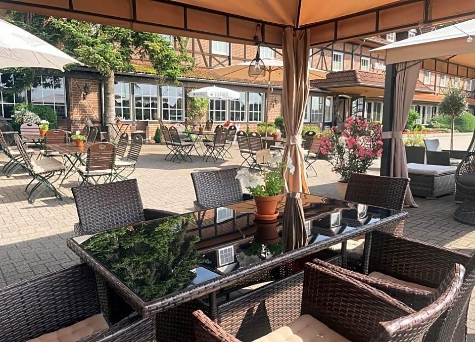 An outdoor patio area with tables and chairs, surrounded by brick walls and potted plants.