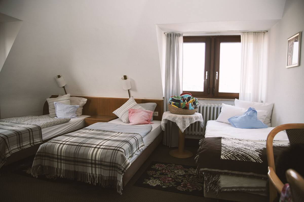 Habitación triple | Cortinas blackout y ropa de cama