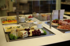 A buffet with various cheeses, grapes, and meats. - Hotel am Main (Veitshoechheim)