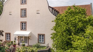 Un bâtiment doté d’une façade incurvée originale, d’un escalier menant à l’entrée et d’une enseigne indiquant qu’il s’agit d’un hôtel certifié GreenSign, niveau 4.