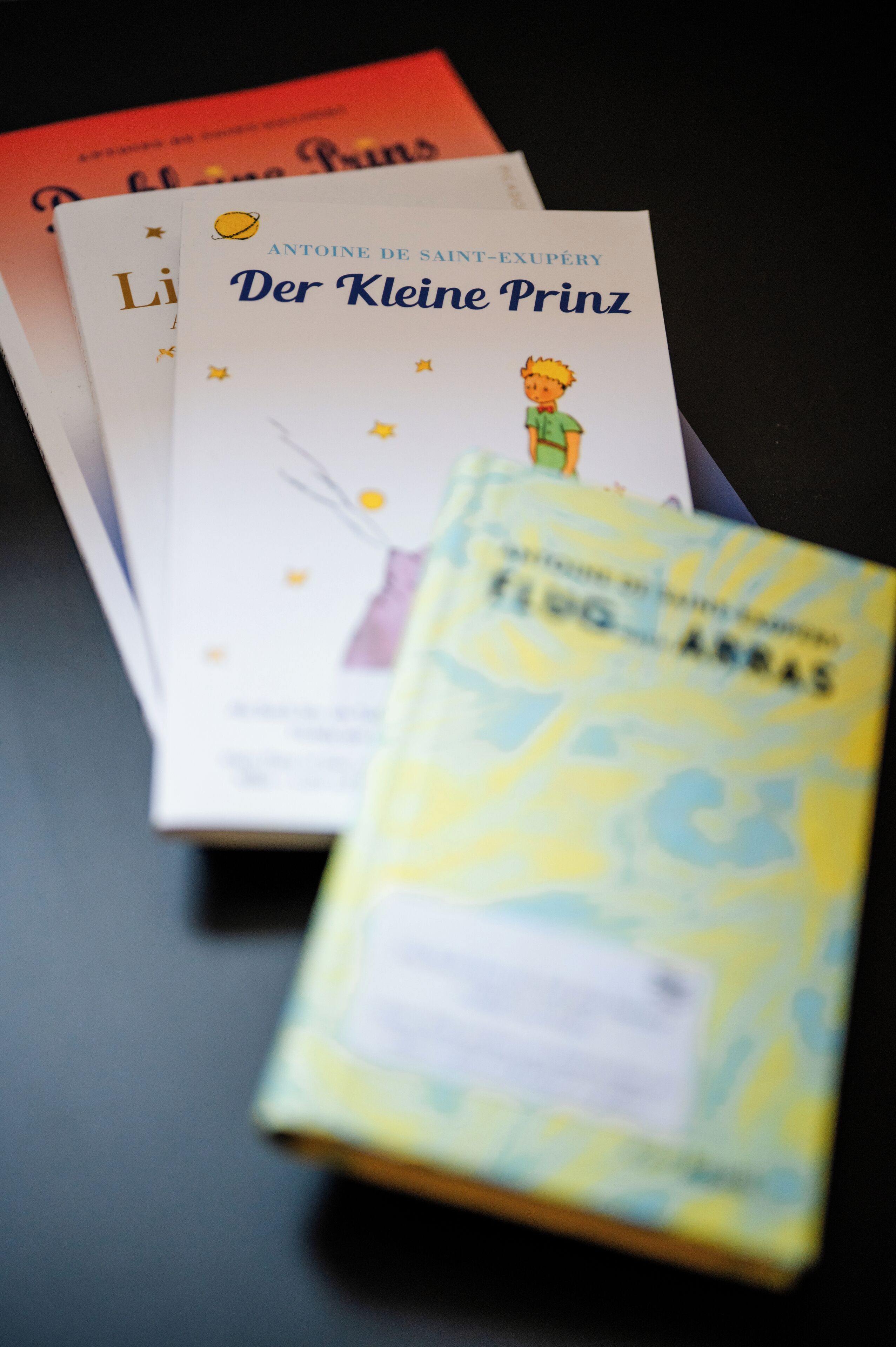A stack of books with visible titles and an illustration of a character.