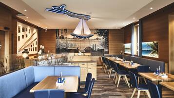 A modern restaurant with wooden walls, blue seating, and a central island.