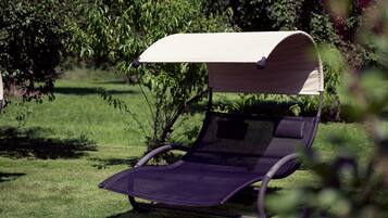 Una silla reclinable con dosel en un espacio al aire libre con césped.