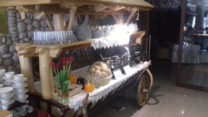 Disposición de buffet con diversos platos y cubiertos.