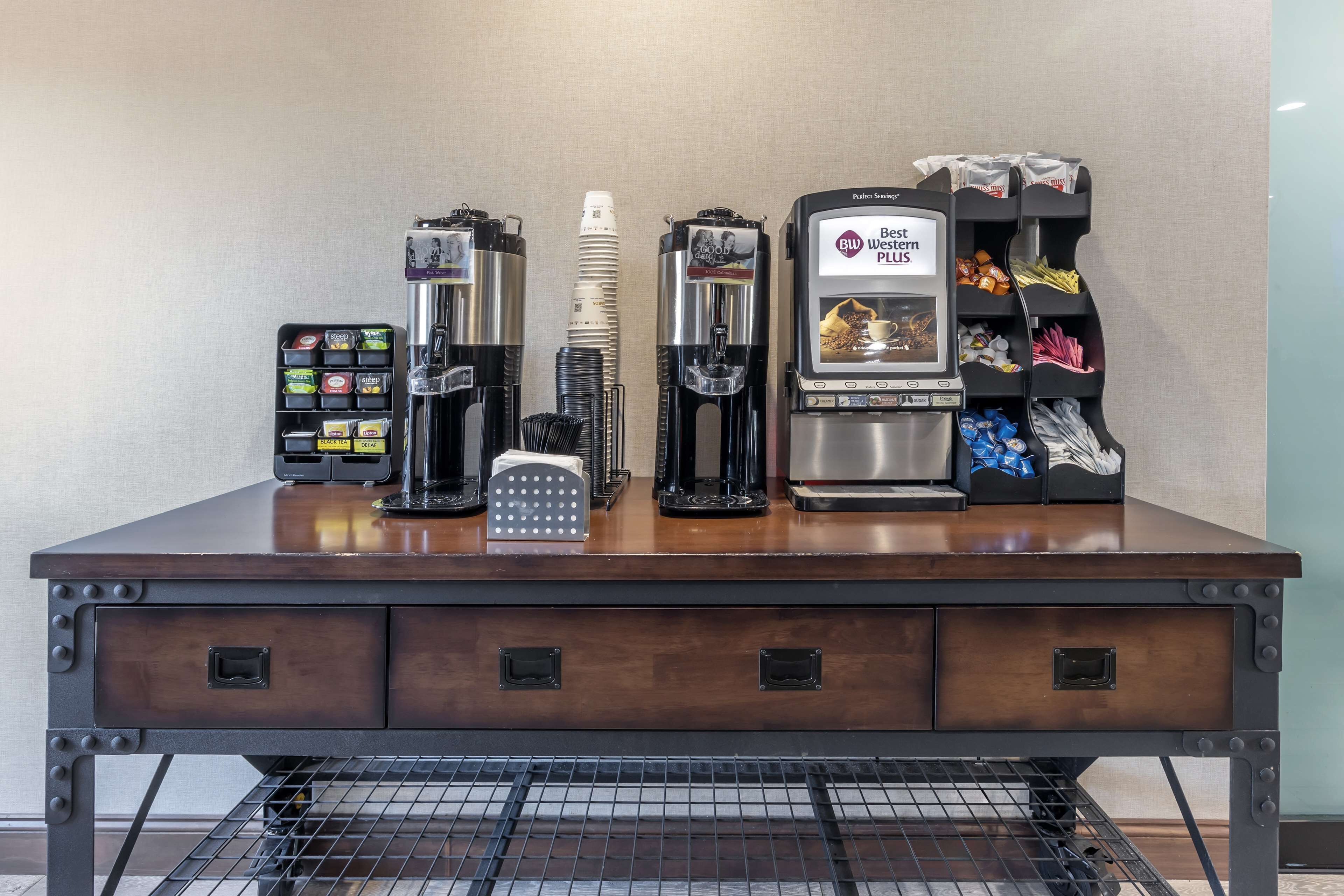 A coffee station with multiple coffee machines, a coffee grinder, and a coffee pod dispenser.