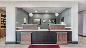 A reception area with a counter, a clock, and framed artwork on the wall. - Best Western Plus Owensboro (Owensboro)