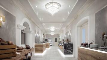 A modern kitchen with a central island, wooden cabinetry, and a chandelier.