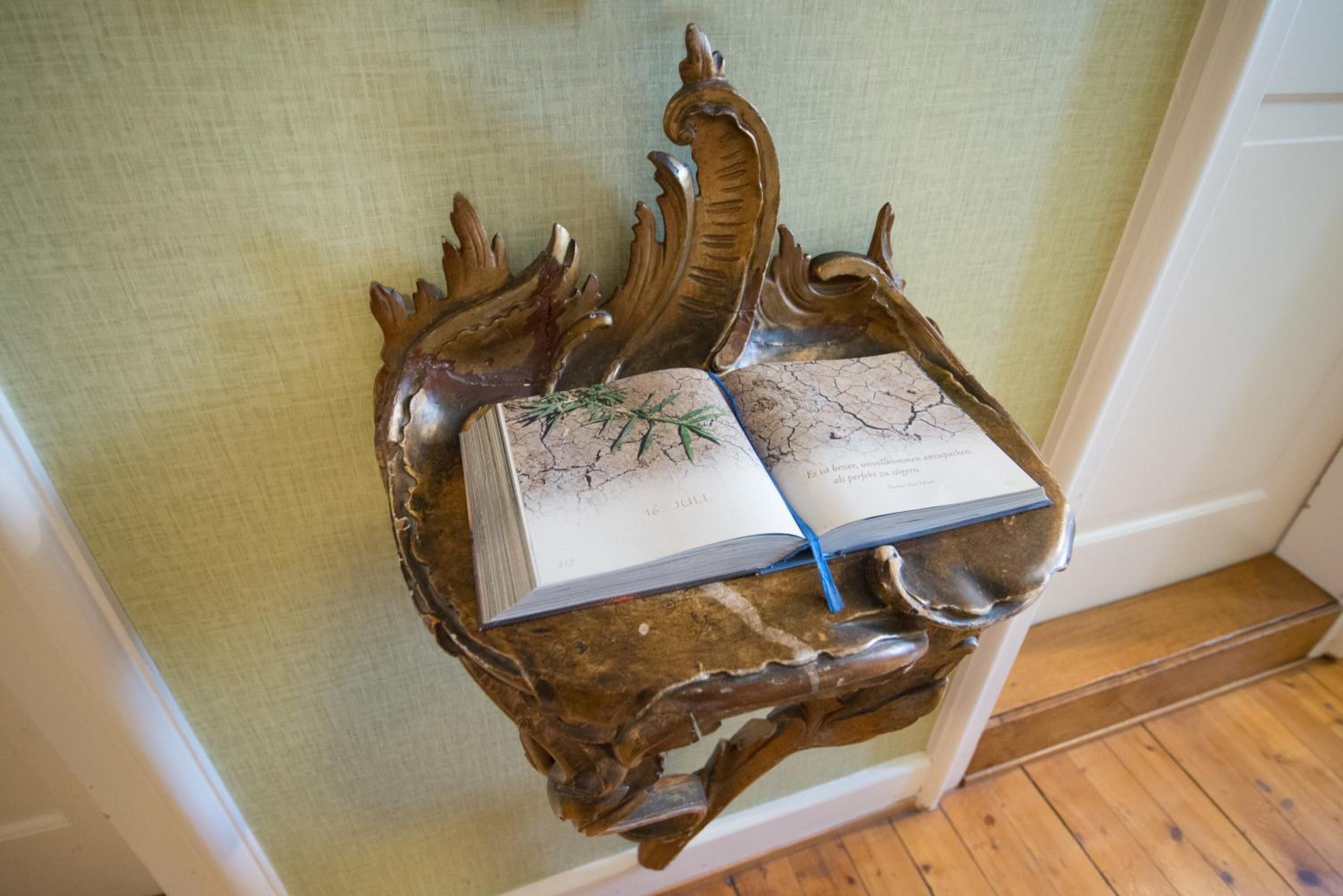 A book on a wooden stand with a textured background.