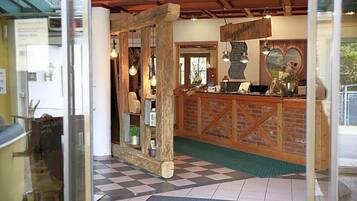 A reception area with a checkered floor, wooden reception desk, and a heart-shaped decoration on the wall.