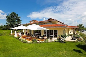 A hotel with outdoor seating and a covered patio area.
