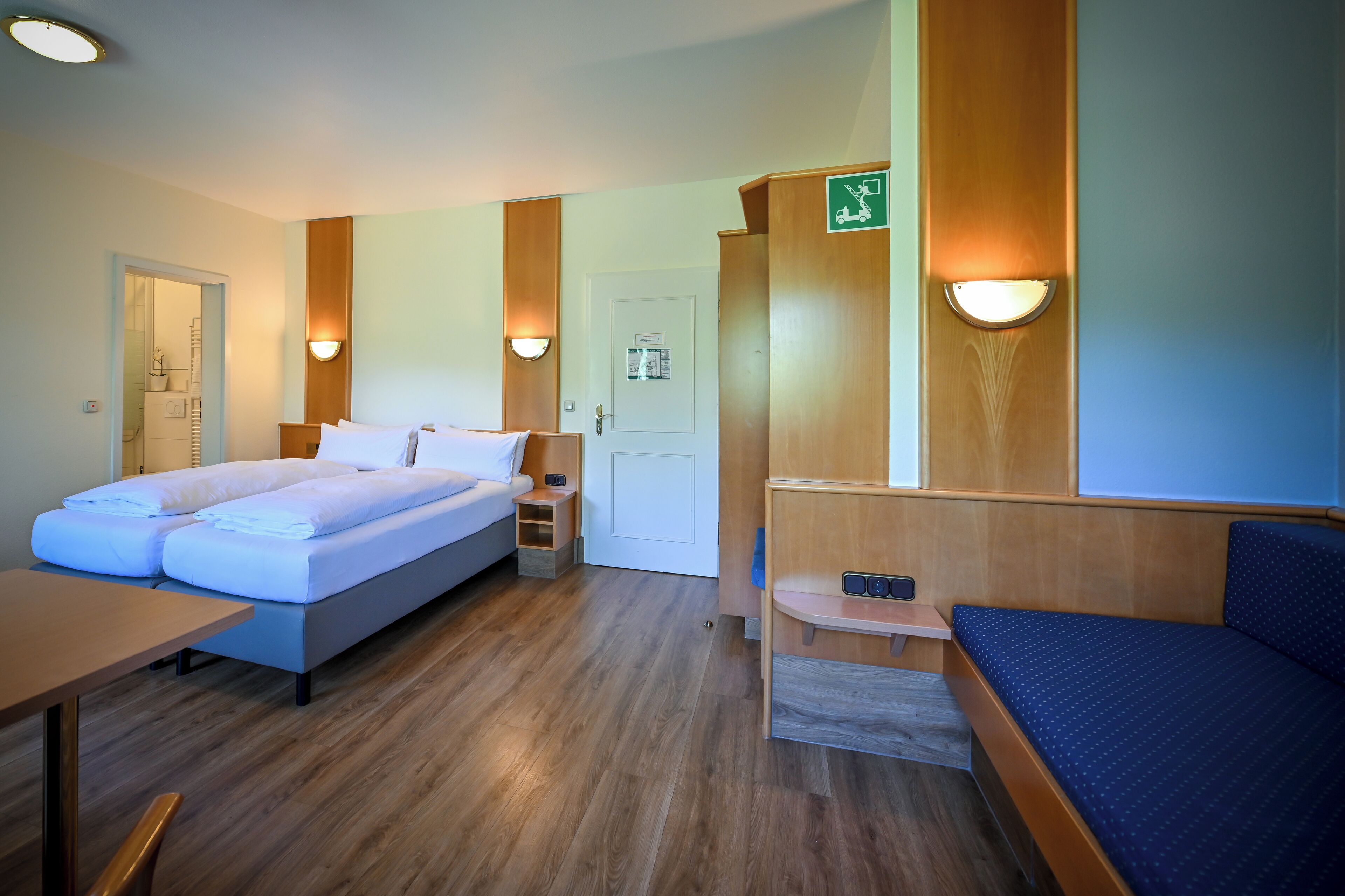 Een hotelkamer met een bed, een bureau en een zithoek.