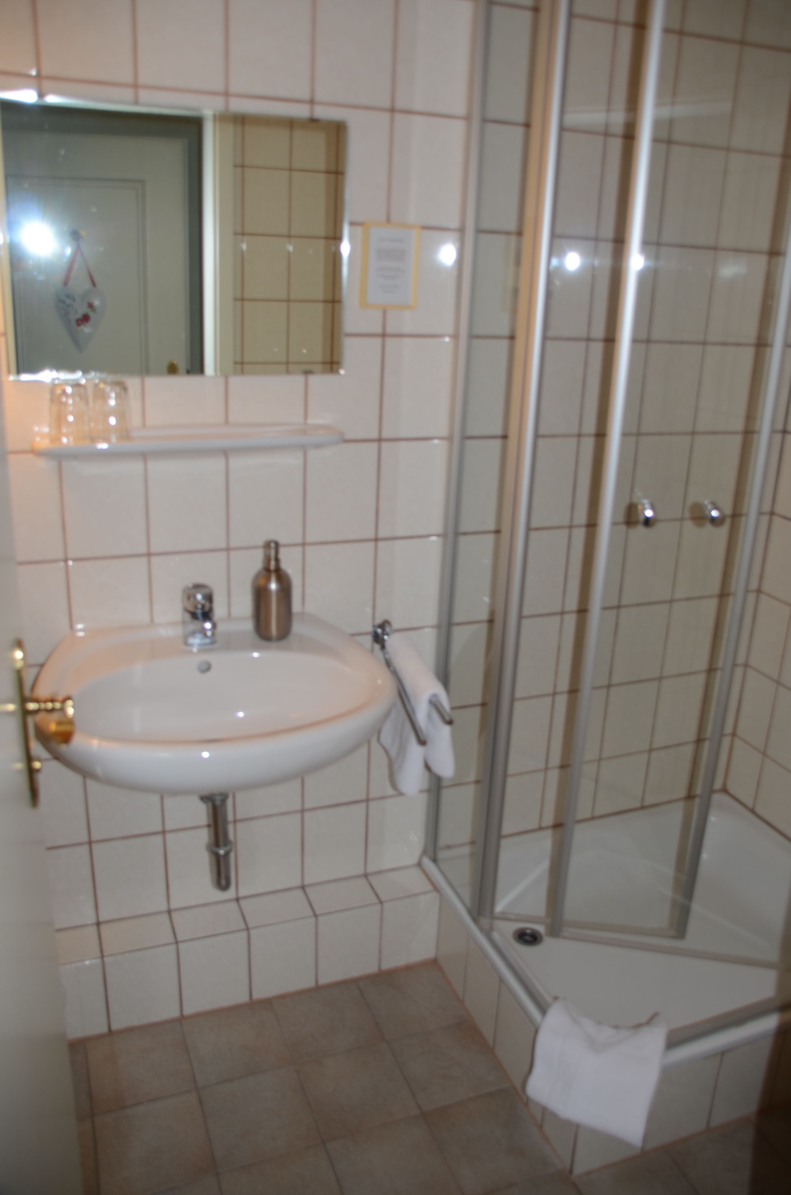 Baño con lavamanos, espejo y ducha.