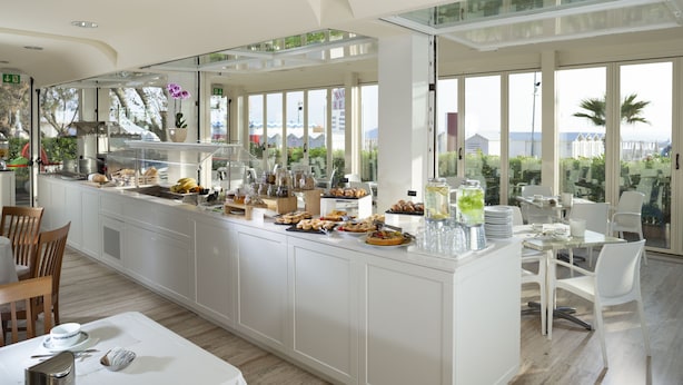 Cozinha moderna com sistema de buffet, janelas grandes e vista para o mar.