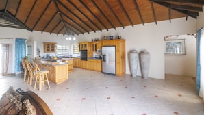 A spacious kitchen with wooden cabinets, a central island, and a large refrigerator. - Forst Villa (Kingstown)