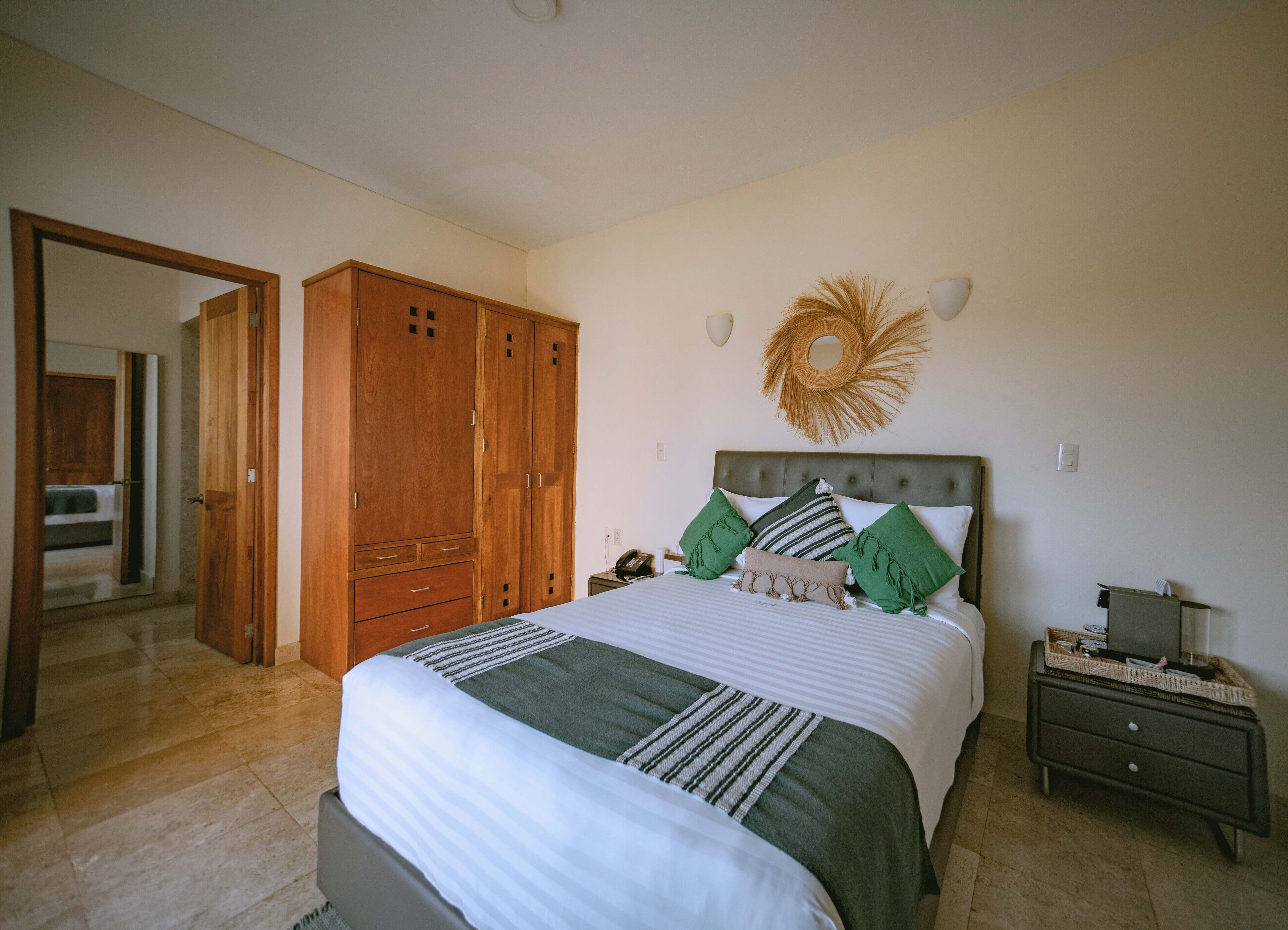 Un dormitorio con cama, armario de madera, mesita de noche y un adorno en la pared.