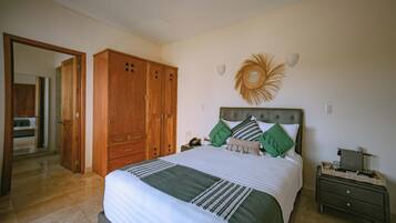 Un dormitorio con cama, armario de madera, mesita de noche y un adorno en la pared.
