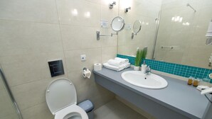A modern bathroom with a toilet, sink, and mirrors.