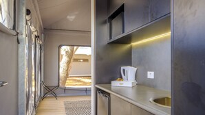 A compact kitchenette with a stainless steel sink, a coffee maker, and a small countertop.