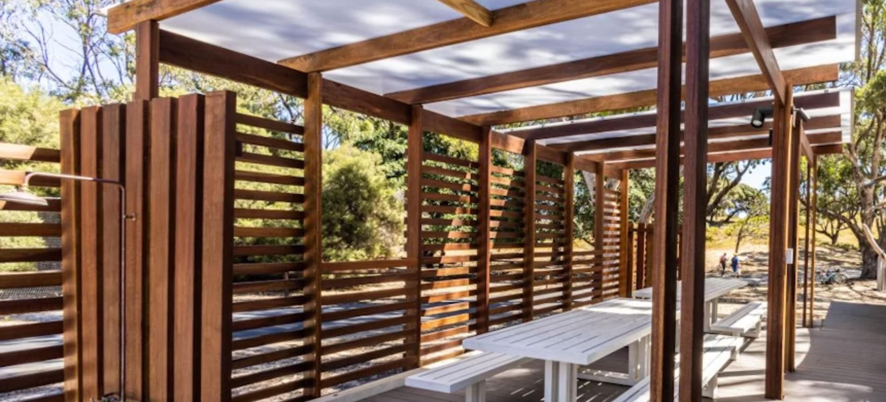 Een houten pergola met bankjes.