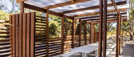 Een houten pergola met bankjes.