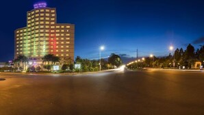 Um hotel com vários andares, janelas iluminadas e um letreiro no topo.