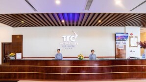 Una recepción de hotel con diseño moderno, que muestra el logo y el nombre del hotel.