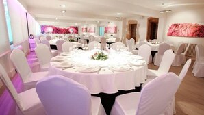 A banquet hall with round tables, white chairs, and floral centerpieces. - LOS Guardeses (Medio Cudeyo)