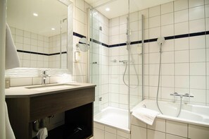 Une salle de bain moderne avec une douche à parois de verre, une baignoire et un meuble-lavabo avec un miroir.